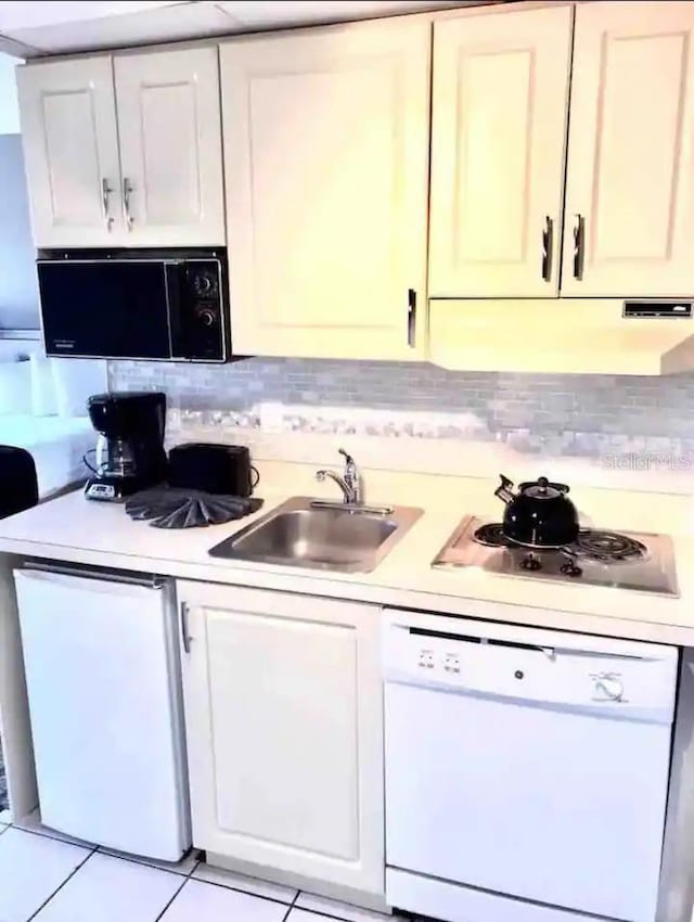 kitchen with white cabinets, white appliances, sink, and light tile patterned floors