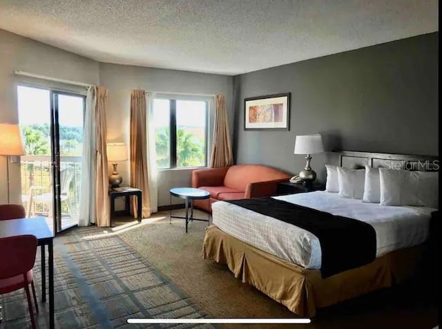 carpeted bedroom featuring access to exterior and a textured ceiling