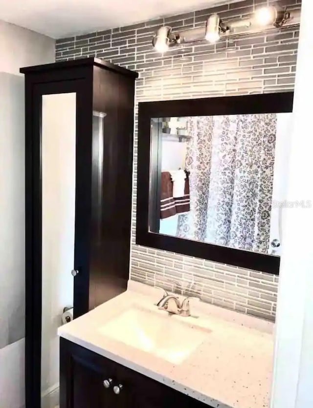 bathroom with vanity and decorative backsplash