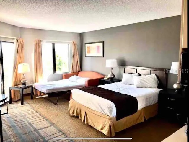 carpeted bedroom featuring a textured ceiling