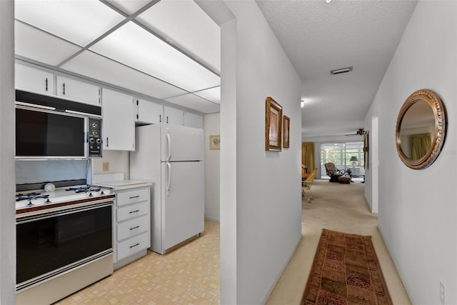 kitchen featuring white cabinets and white appliances