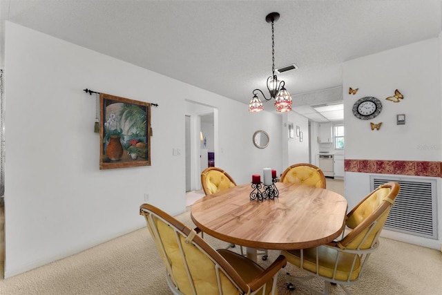 carpeted dining room featuring a textured ceiling and a notable chandelier