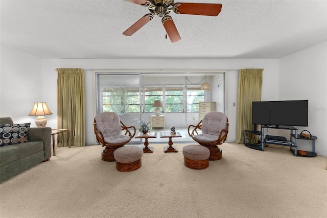 carpeted living room featuring a textured ceiling and ceiling fan