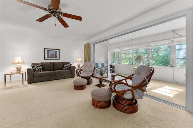 living room with carpet flooring, a textured ceiling, and ceiling fan