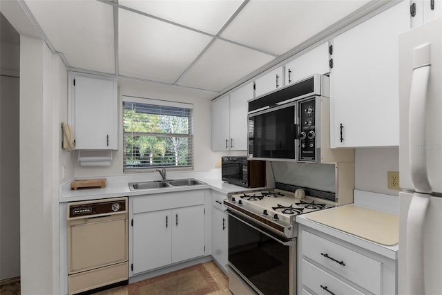 kitchen with white appliances, sink, and white cabinets