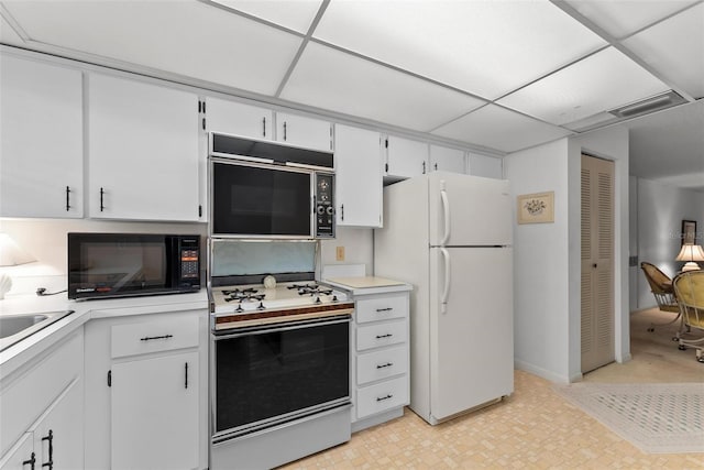 kitchen featuring white cabinets, a paneled ceiling, and white appliances