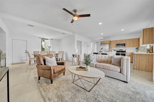 living room featuring ceiling fan, light tile patterned flooring, and sink