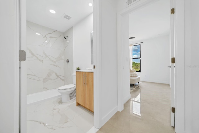 bathroom with tiled shower and vanity