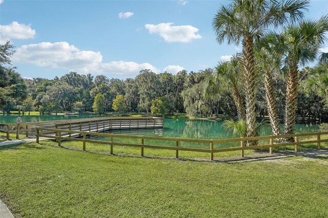 surrounding community with a water view and a yard