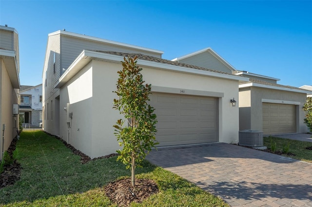 view of side of property with central AC unit and a garage