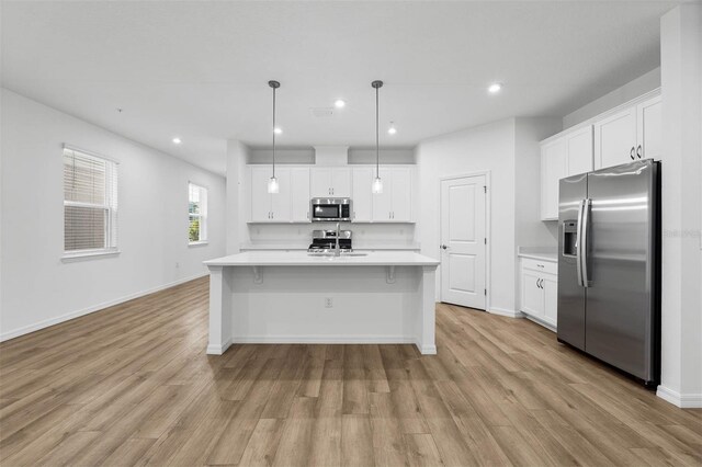 kitchen with white cabinetry, sink, pendant lighting, and appliances with stainless steel finishes