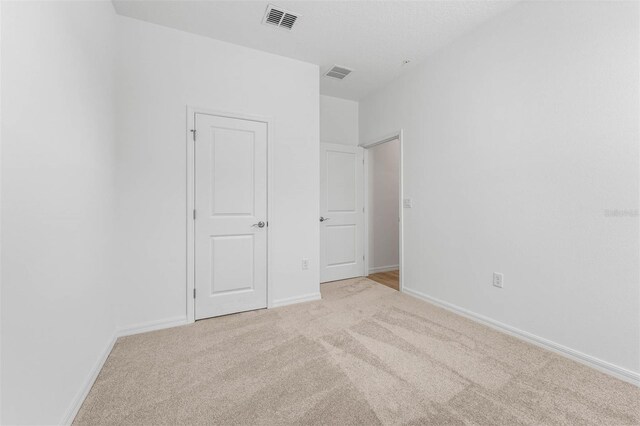 spare room featuring light colored carpet