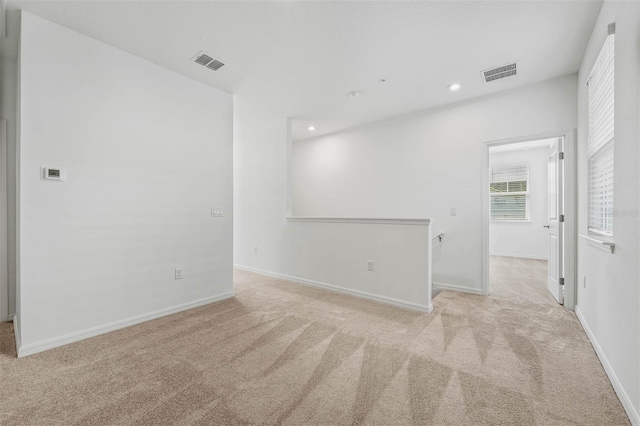 spare room featuring light colored carpet