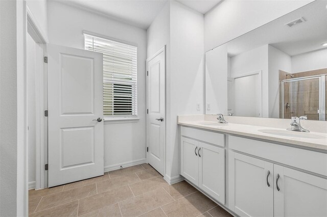 bathroom featuring vanity, tile patterned floors, and a shower with shower door