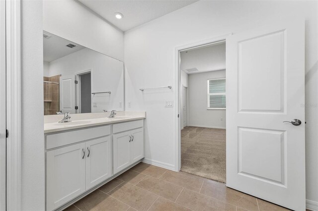 bathroom with vanity, tile patterned flooring, and a shower