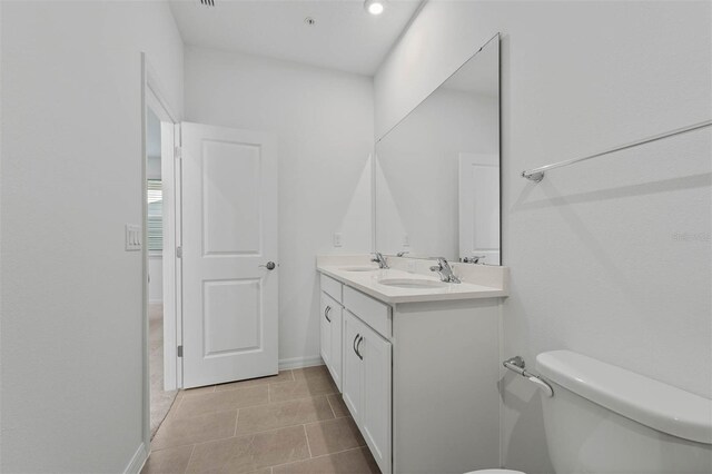 bathroom featuring vanity, tile patterned floors, and toilet