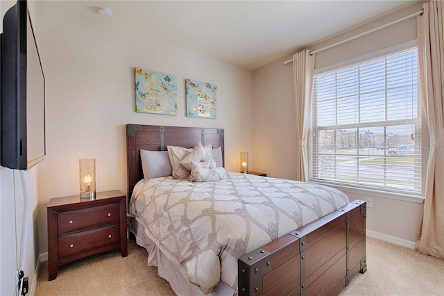 bedroom featuring light colored carpet and multiple windows