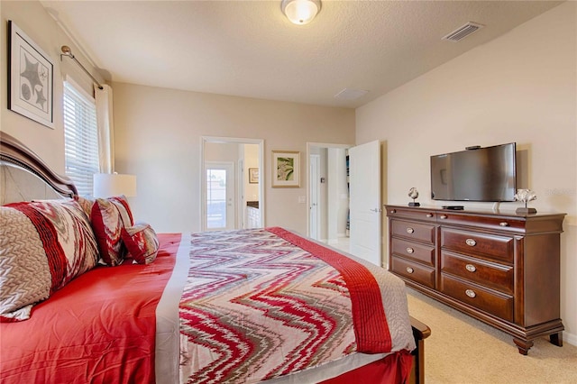 bedroom featuring a textured ceiling and light carpet