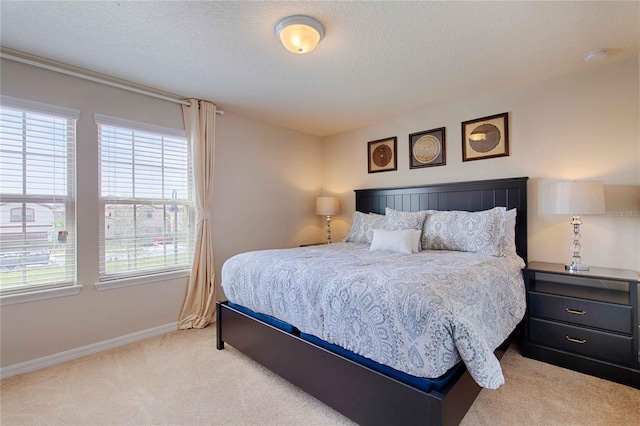 bedroom with a textured ceiling and light carpet