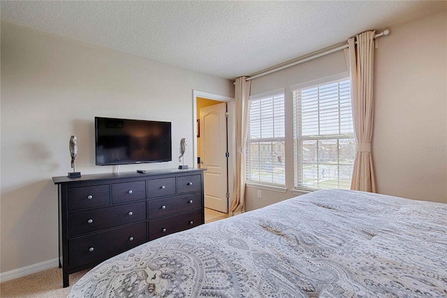 bedroom with light colored carpet and a textured ceiling