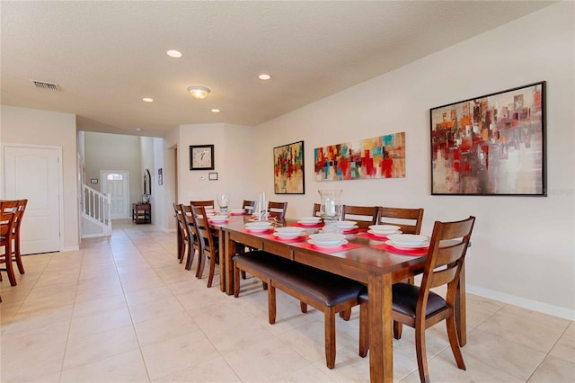 tiled dining room featuring a textured ceiling