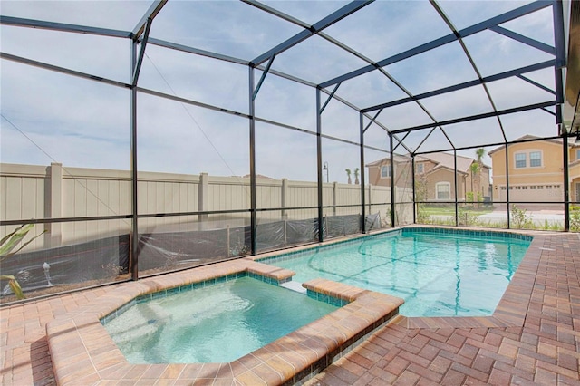 view of swimming pool featuring a lanai, an in ground hot tub, and a patio area