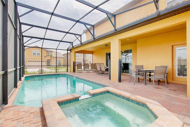 view of pool featuring a patio, a lanai, and an in ground hot tub