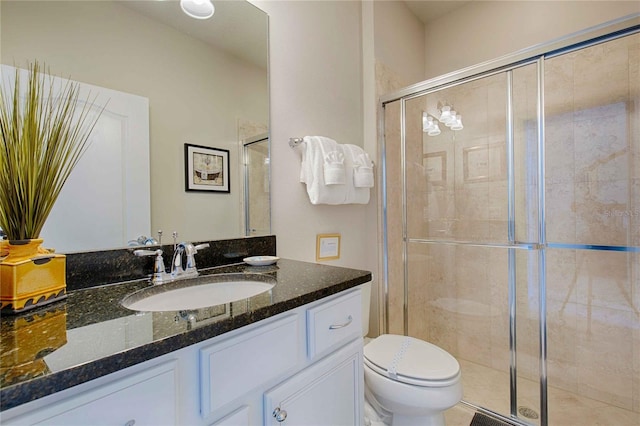 bathroom with vanity, toilet, and a shower with door