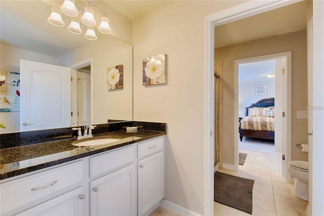 bathroom with toilet, vanity, tile patterned flooring, and a shower with shower door