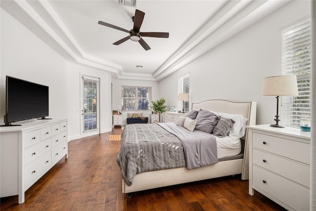 bedroom featuring visible vents, a raised ceiling, ceiling fan, dark wood-style flooring, and access to exterior