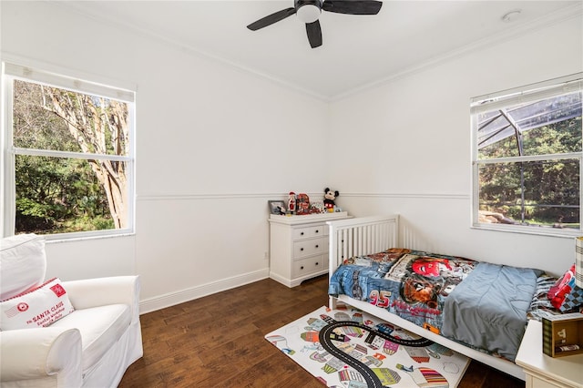 bedroom featuring baseboards, multiple windows, ornamental molding, and wood finished floors