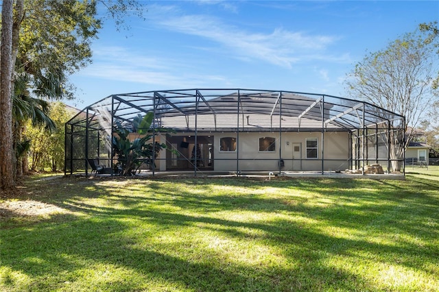 rear view of property with glass enclosure and a yard