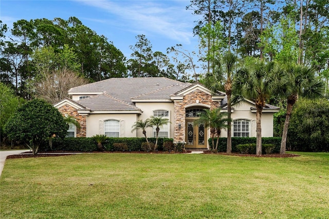 view of front facade featuring stone siding, a front yard, and stucco siding