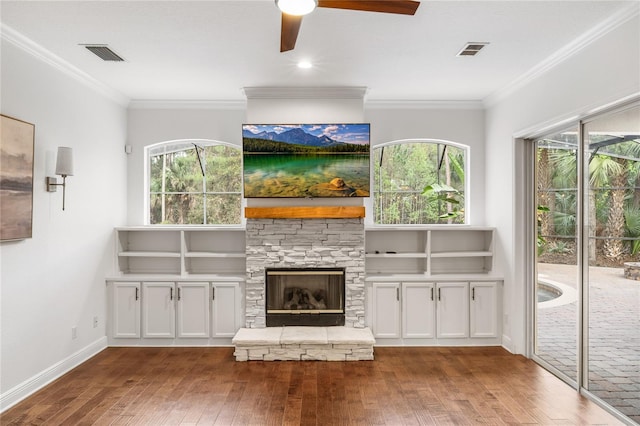 unfurnished living room featuring hardwood / wood-style floors, a fireplace, visible vents, and crown molding