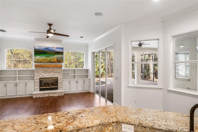 interior space with crown molding, a fireplace, ceiling fan, and hardwood / wood-style flooring