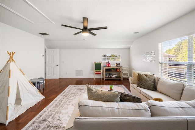 living room with ceiling fan, dark wood finished floors, visible vents, and baseboards