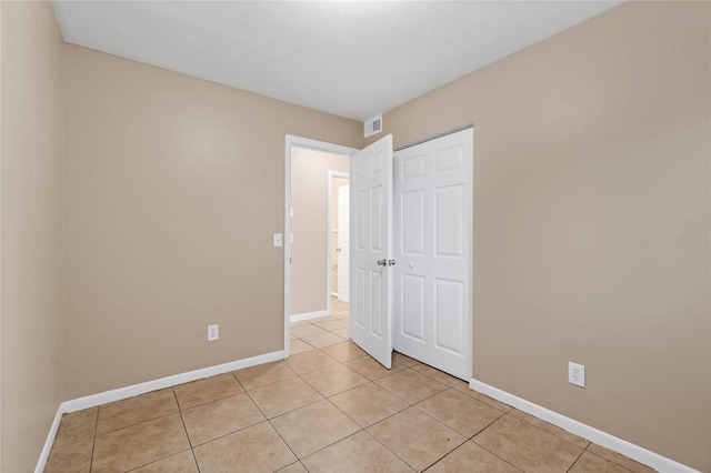 unfurnished bedroom featuring light tile patterned flooring and a closet