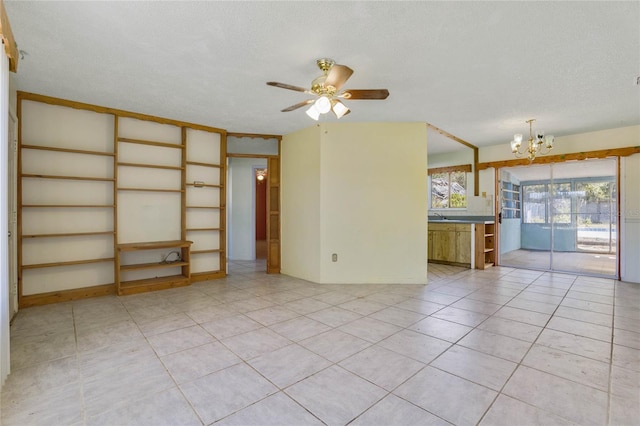 unfurnished living room featuring ceiling fan with notable chandelier, light tile patterned floors, and a textured ceiling