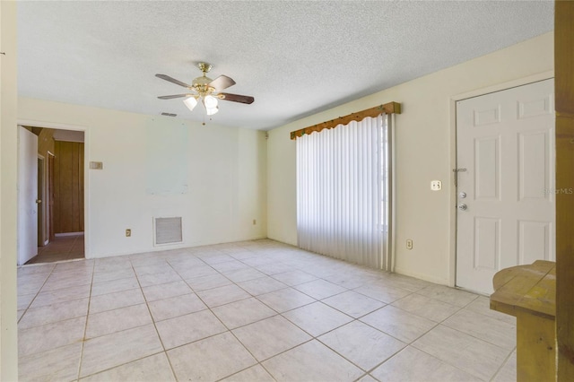 tiled spare room with ceiling fan and a textured ceiling