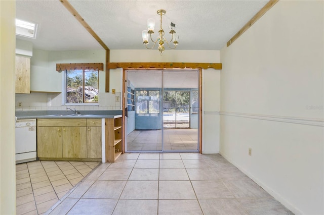 kitchen featuring white dishwasher, light tile patterned floors, a textured ceiling, and a chandelier