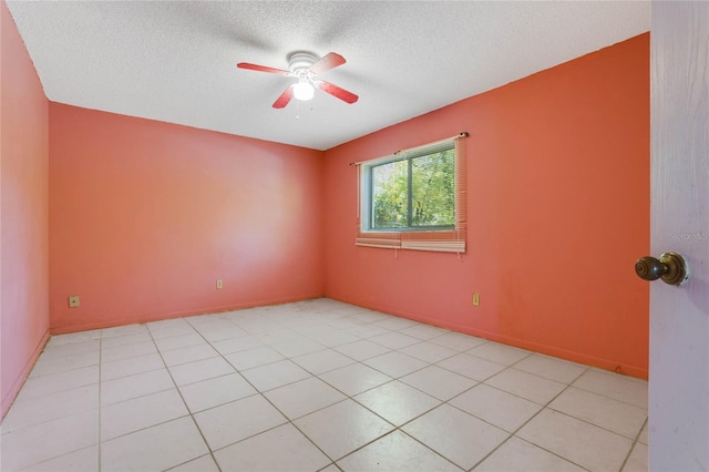 tiled empty room with ceiling fan and a textured ceiling