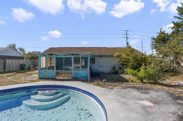 view of swimming pool featuring a sunroom and a patio area