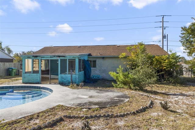 rear view of house with a sunroom and a hot tub