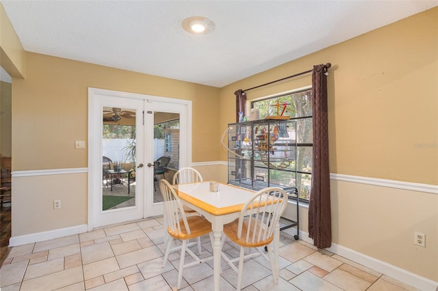 tiled dining area featuring a textured ceiling and french doors