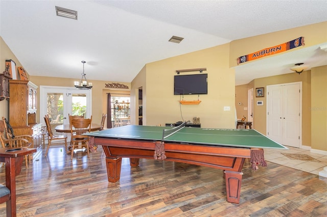 game room with french doors, dark hardwood / wood-style flooring, a textured ceiling, and vaulted ceiling