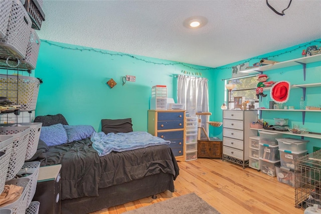 bedroom featuring hardwood / wood-style floors and a textured ceiling