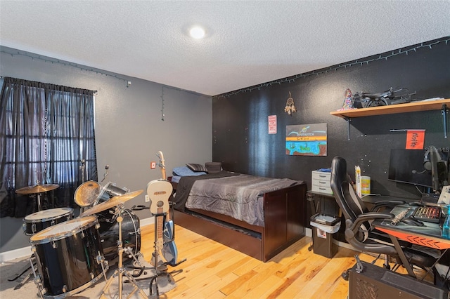 bedroom with wood-type flooring and a textured ceiling