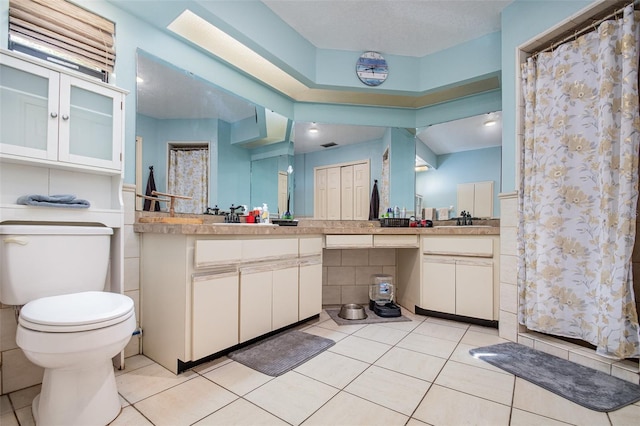 bathroom with tile patterned floors, walk in shower, vanity, tile walls, and toilet