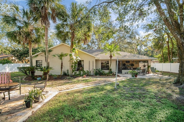 view of front of house featuring a front lawn and a patio