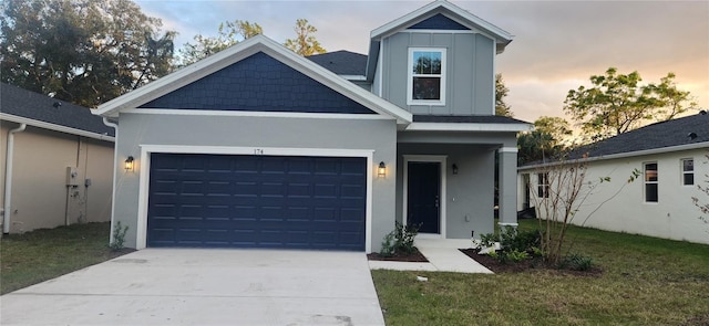 view of front of house featuring an attached garage, driveway, a yard, stucco siding, and board and batten siding